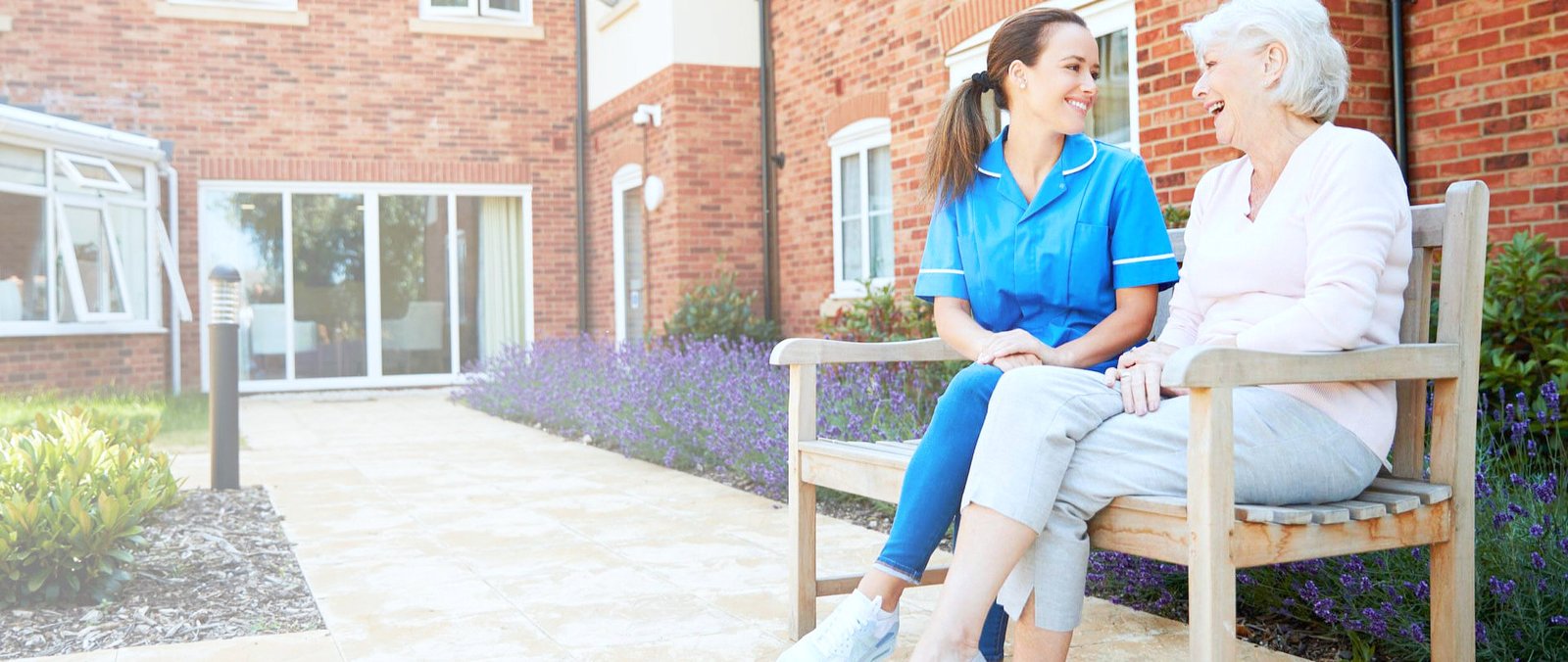 senior woman talking with a caregiver on a bench
