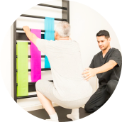 male caretaker assisting an elderly man doung physical therapy
