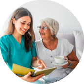elderly woman holdy a tea cup taking with a female caregiver