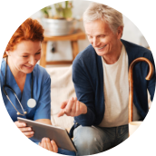 female nurse taking to an elderly man with a cane